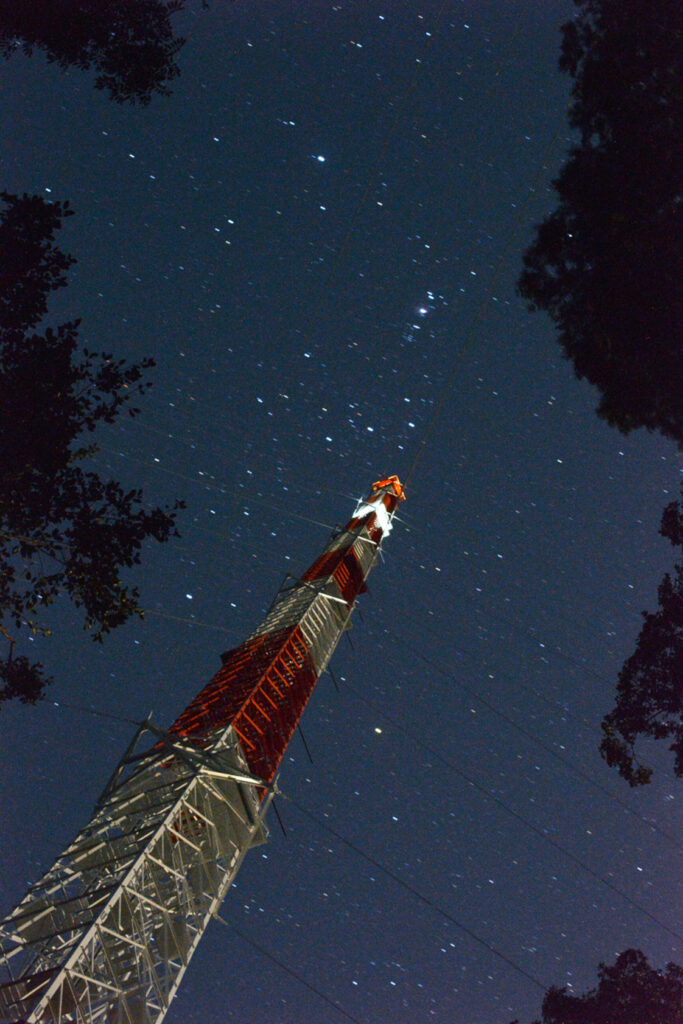 Looking up the tall tower, with a dark, starry sky behind it.